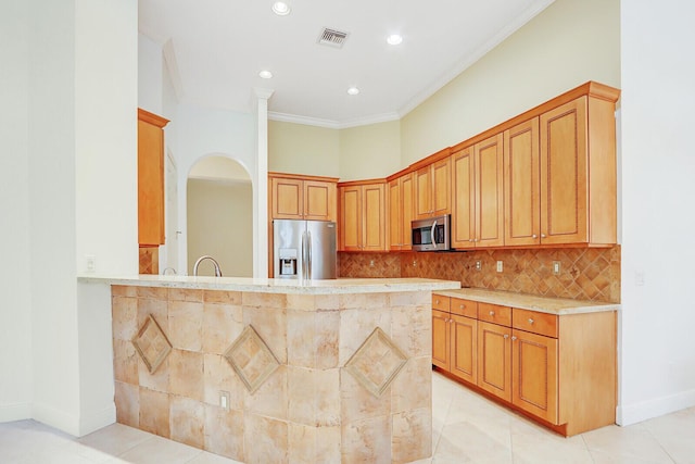 9400 Briarcliff Trce, Port Saint Lucie, FL 34986 - kitchen featuring appliances with stainless steel finishes, ornamental molding, light countertops, tasteful backsplash, and a peninsula