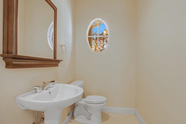 9400 Briarcliff Trce, Port Saint Lucie, FL 34986 - half bathroom featuring toilet, baseboards, tile patterned flooring, and a sink