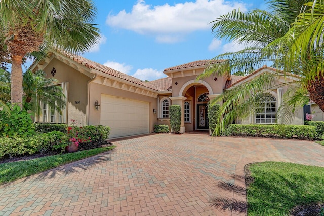 9400 Briarcliff Trce, Port Saint Lucie, FL 34986 - mediterranean / spanish-style house with an attached garage, stucco siding, a tile roof, and decorative driveway