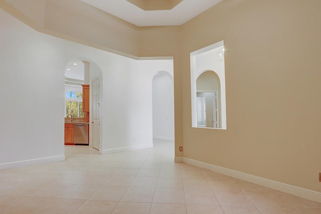 9400 Briarcliff Trce, Port Saint Lucie, FL 34986 - empty room with light tile patterned floors, arched walkways, a sink, and baseboards