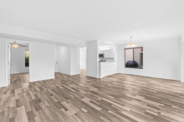 10679 Ocean Palm Way Unit 101, Boynton Beach, FL 33437 - unfurnished living room with wood finished floors, baseboards, and a chandelier