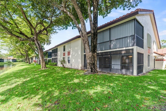 10679 Ocean Palm Way Unit 101, Boynton Beach, FL 33437 - rear view of property with a tile roof, stucco siding, and a yard