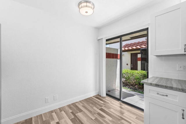 10679 Ocean Palm Way Unit 101, Boynton Beach, FL 33437 - unfurnished dining area featuring light wood-style flooring and baseboards