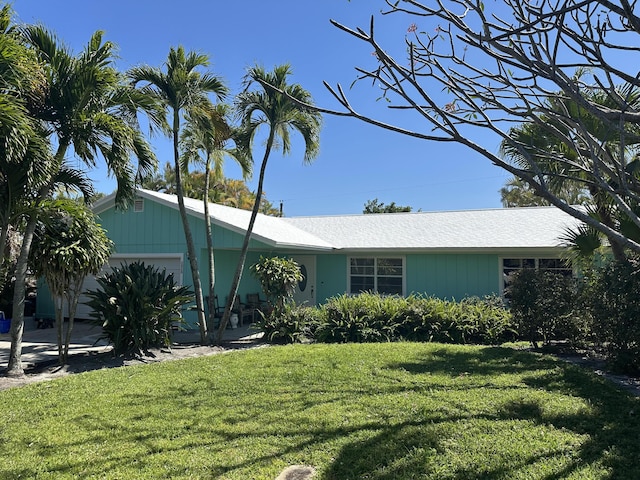 ranch-style home with a garage and a front lawn