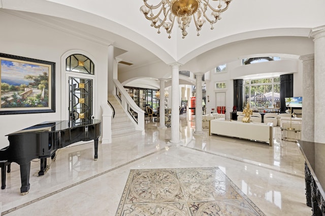 foyer entrance with decorative columns, a chandelier, marble tiled flooring, and arched walkways