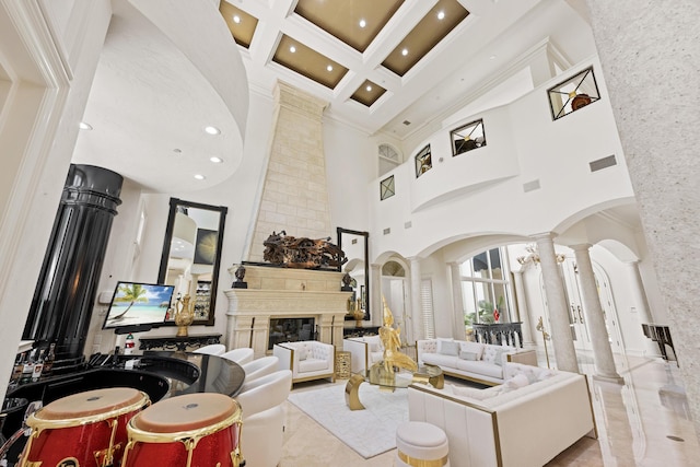 living area featuring ornate columns, a towering ceiling, arched walkways, beamed ceiling, and recessed lighting