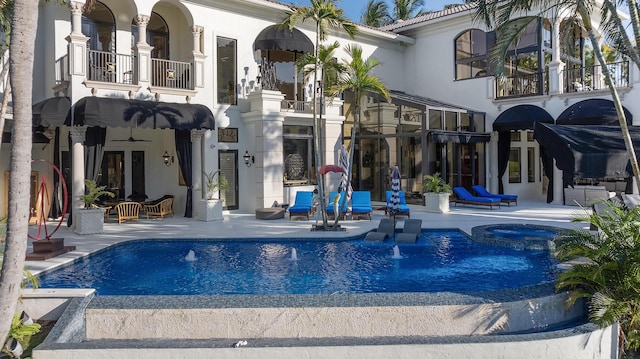 view of swimming pool with a patio, a pool with connected hot tub, and french doors
