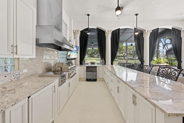 kitchen featuring arched walkways, exhaust hood, refrigerator, white cabinetry, and a textured ceiling