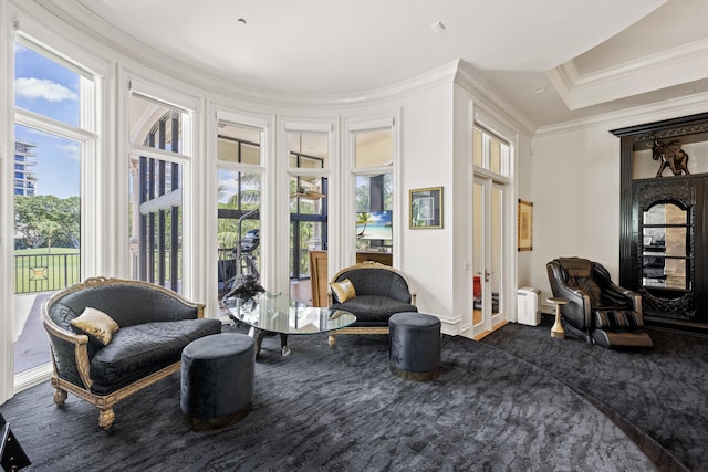 sitting room with french doors, crown molding, dark carpet, and healthy amount of natural light