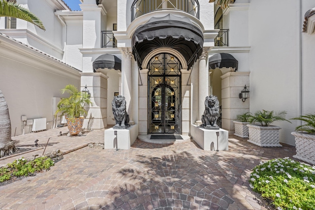 entrance to property featuring french doors and stucco siding