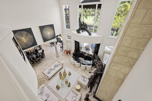 living area with a towering ceiling and plenty of natural light