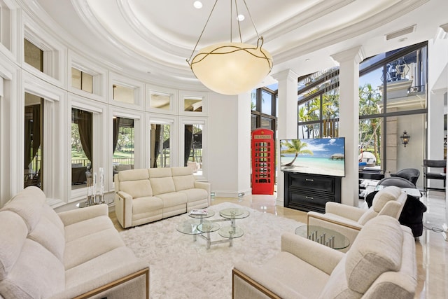 living room featuring ornamental molding, decorative columns, a high ceiling, a tray ceiling, and recessed lighting