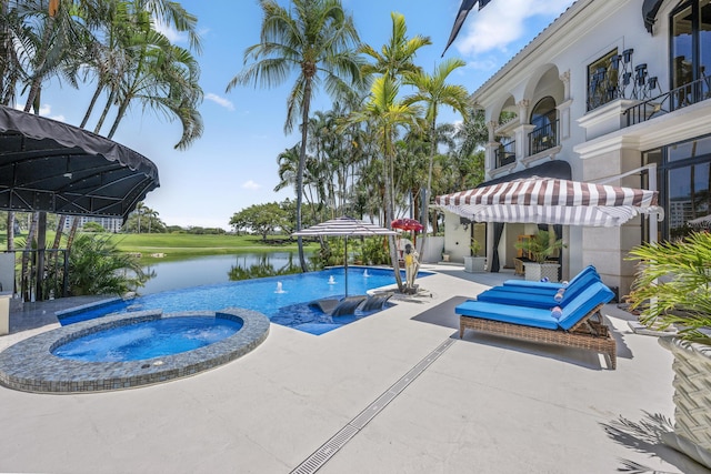 view of swimming pool with a pool with connected hot tub, a patio, and a water view