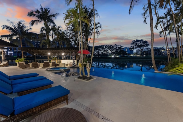view of pool featuring an outdoor living space, a patio, an in-ground hot tub, and a water view