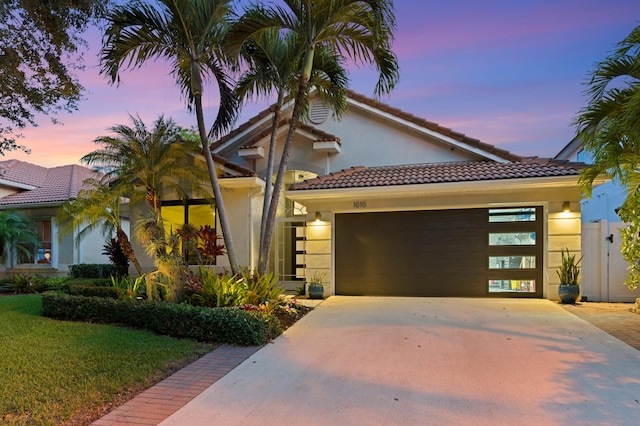 1010 Delray Lakes Dr, Delray Beach, FL 33444 - mediterranean / spanish house with stucco siding, an attached garage, concrete driveway, and a tiled roof
