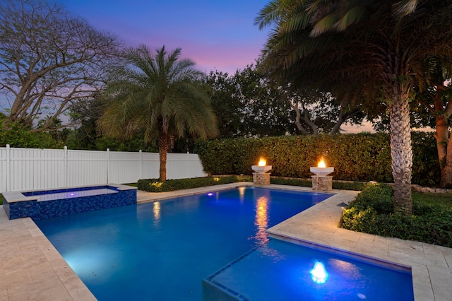 1010 Delray Lakes Dr, Delray Beach, FL 33444 - pool at dusk featuring a pool with connected hot tub and a fenced backyard