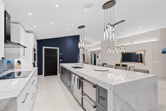 1010 Delray Lakes Dr, Delray Beach, FL 33444 - kitchen with black electric stovetop, a sink, wall chimney range hood, a large island, and white cabinetry