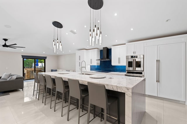 1010 Delray Lakes Dr, Delray Beach, FL 33444 - kitchen featuring a sink, wall chimney exhaust hood, a spacious island, light tile patterned floors, and recessed lighting