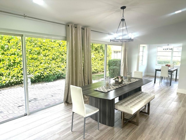 dining area with a chandelier, wood finished floors, and baseboards