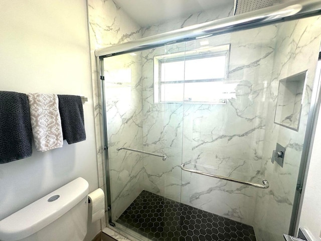bathroom with toilet and a marble finish shower