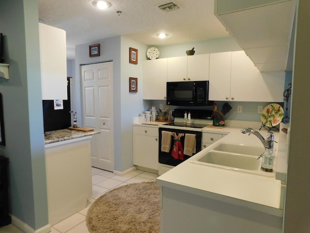 kitchen featuring black microwave, range with electric stovetop, a sink, light tile patterned flooring, and light countertops