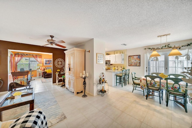 9152 Affirmed Ln, Boca Raton, FL 33496 - living room featuring a ceiling fan, a textured ceiling, light tile patterned flooring, and baseboards