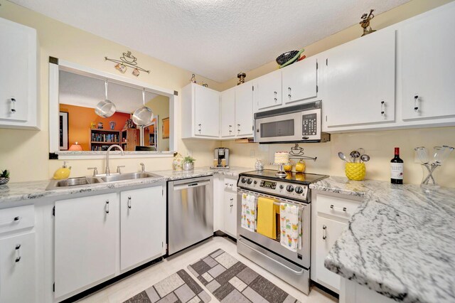 9152 Affirmed Ln, Boca Raton, FL 33496 - kitchen with stainless steel appliances, a sink, white cabinets, and a textured ceiling