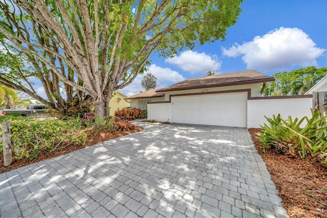 9152 Affirmed Ln, Boca Raton, FL 33496 - view of front of home with stucco siding, a garage, decorative driveway, and fence