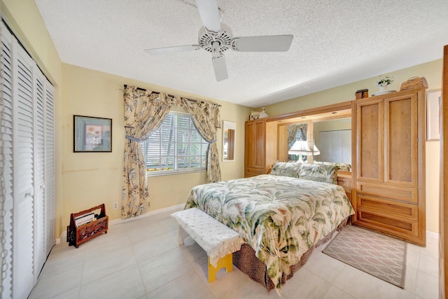 9152 Affirmed Ln, Boca Raton, FL 33496 - bedroom featuring a textured ceiling, a closet, light tile patterned floors, ceiling fan, and baseboards
