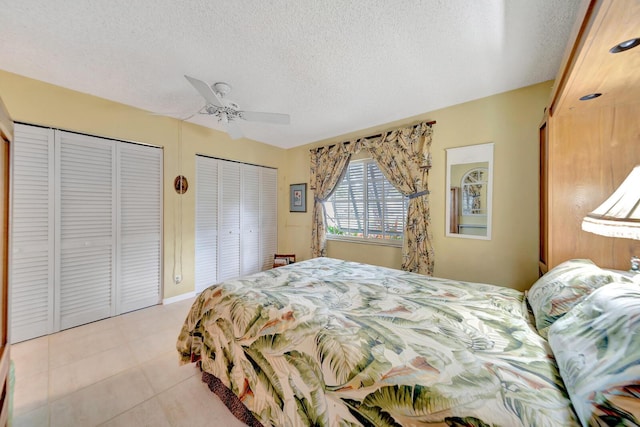 9152 Affirmed Ln, Boca Raton, FL 33496 - bedroom with two closets, a textured ceiling, light tile patterned floors, and a ceiling fan