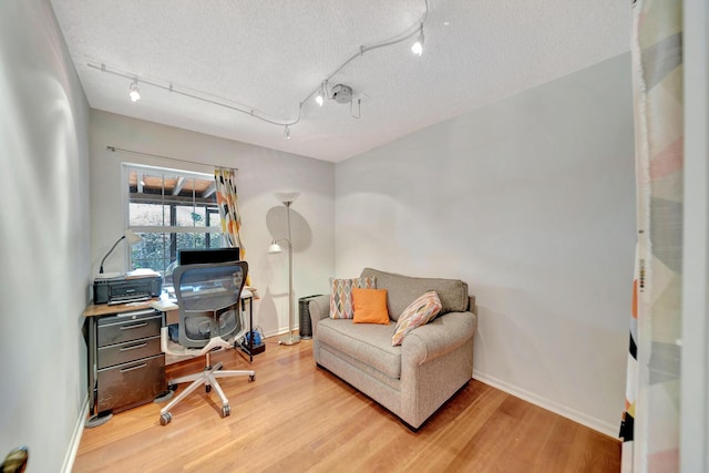 9152 Affirmed Ln, Boca Raton, FL 33496 - home office featuring rail lighting, light wood-style floors, a textured ceiling, and baseboards