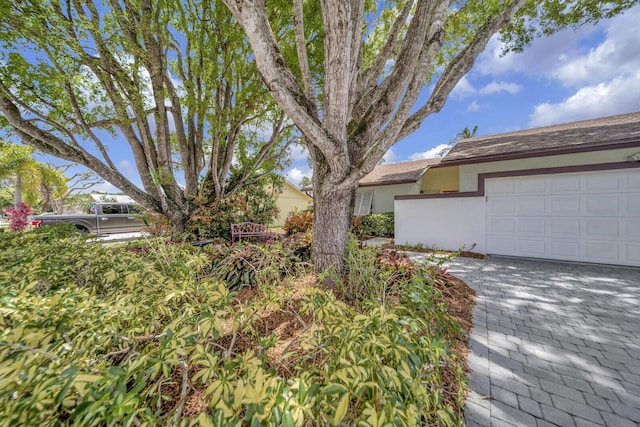 9152 Affirmed Ln, Boca Raton, FL 33496 - view of front facade with stucco siding, a garage, a shingled roof, and driveway