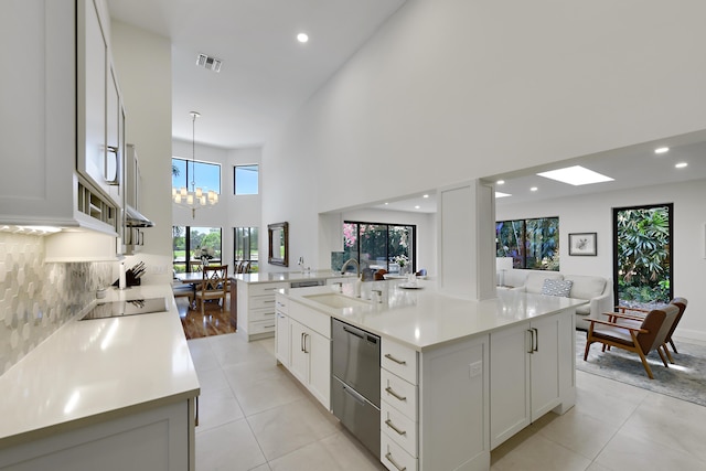 4054 SW Gleneagle Cir, Palm City, FL 34990 - kitchen featuring a sink, a towering ceiling, recessed lighting, light countertops, and a chandelier