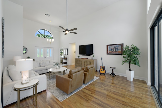 4054 SW Gleneagle Cir, Palm City, FL 34990 - living area featuring light wood-style flooring, a ceiling fan, a towering ceiling, baseboards, and french doors