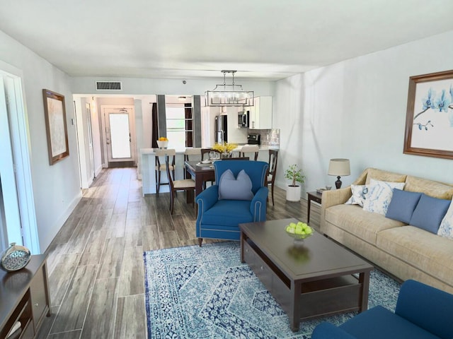 14527 Bonaire Blvd Unit 306, Delray Beach, FL 33446 - living room featuring wood finished floors, a chandelier, and baseboards