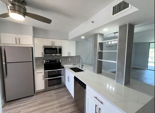 14527 Bonaire Blvd Unit 306, Delray Beach, FL 33446 - kitchen with stainless steel appliances, a sink, ceiling fan, white cabinetry, and light wood-type flooring