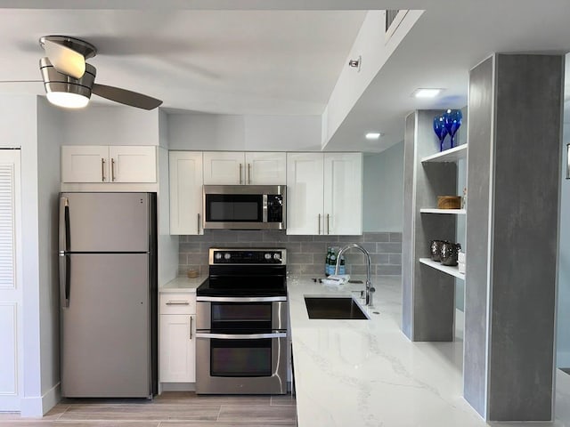 14527 Bonaire Blvd Unit 306, Delray Beach, FL 33446 - kitchen with stainless steel appliances, a sink, open shelves, light stone counters, and ceiling fan