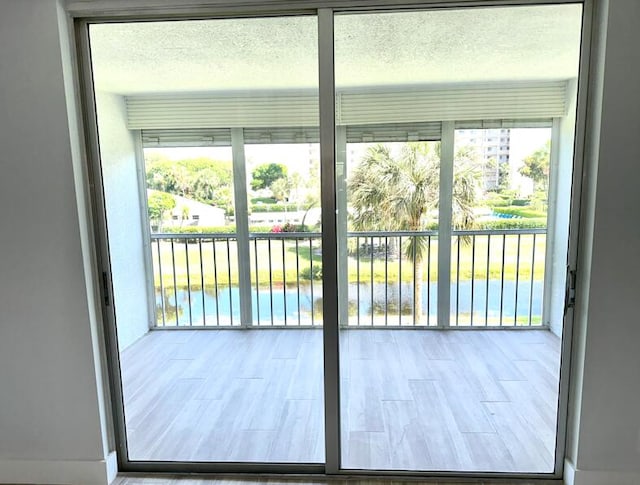14527 Bonaire Blvd Unit 306, Delray Beach, FL 33446 - doorway with a textured ceiling and wood finished floors