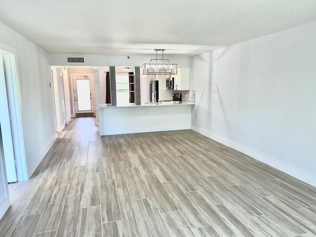 14527 Bonaire Blvd Unit 306, Delray Beach, FL 33446 - unfurnished living room featuring light wood-style flooring, baseboards, and a chandelier