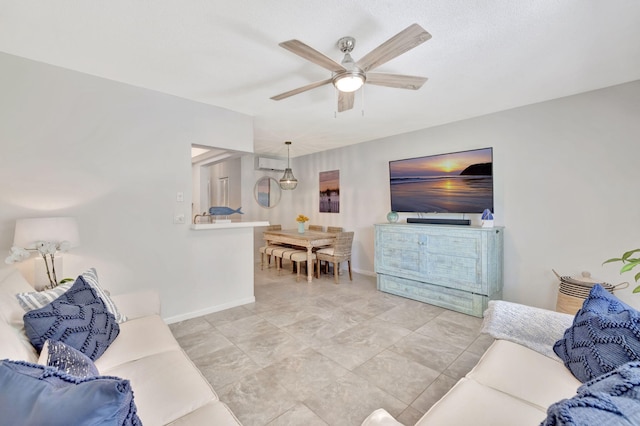 living area featuring ceiling fan and baseboards