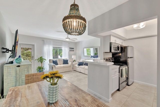 kitchen featuring appliances with stainless steel finishes, a chandelier, light tile patterned floors, white cabinets, and baseboards
