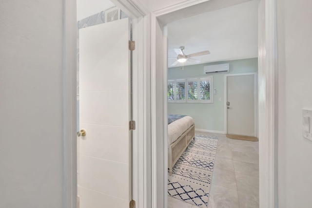 bathroom with a wall mounted AC, ceiling fan, tile patterned flooring, and baseboards
