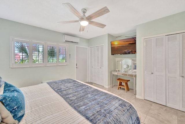 bedroom with two closets, a wall mounted AC, tile patterned flooring, and a ceiling fan