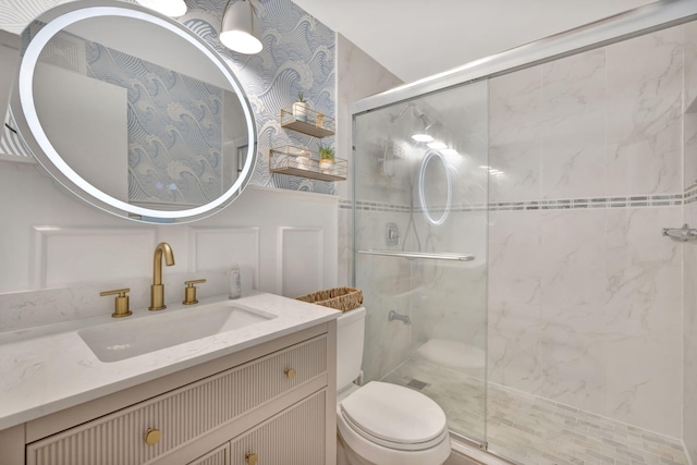 bathroom with toilet, a shower stall, and vanity