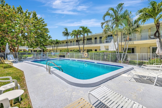community pool with fence and a patio