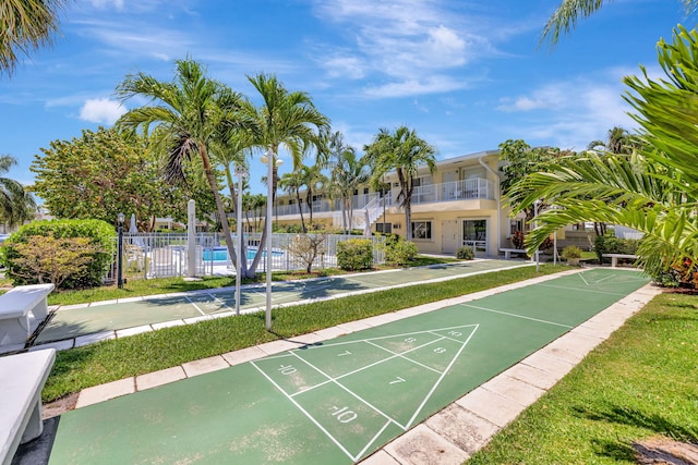 view of home's community with fence and shuffleboard