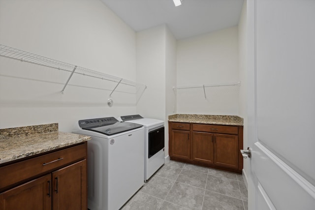 4641 Woodland Way, Westlake, FL 33470 - clothes washing area with washing machine and dryer, light tile patterned floors, and cabinet space