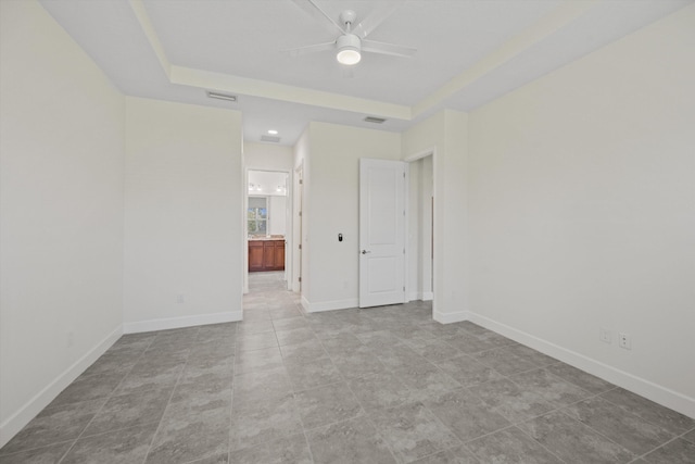 4641 Woodland Way, Westlake, FL 33470 - spare room featuring a ceiling fan, a tray ceiling, baseboards, and tile patterned floors