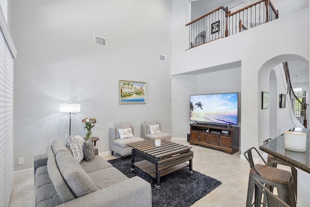 12341 NW 78th Mnr, Parkland, FL 33076 - living area featuring arched walkways, light tile patterned floors, baseboards, and a high ceiling