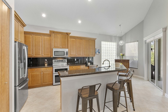 12341 NW 78th Mnr, Parkland, FL 33076 - kitchen featuring stainless steel appliances, light tile patterned flooring, lofted ceiling, decorative backsplash, and a sink